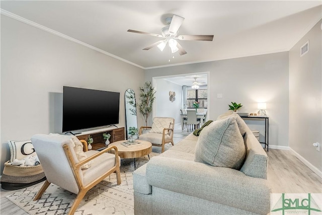 living room featuring ornamental molding and light hardwood / wood-style flooring