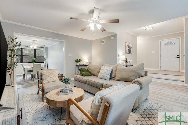 living room featuring ceiling fan, light hardwood / wood-style floors, and ornamental molding