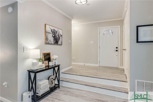 entryway with light hardwood / wood-style floors and ornamental molding