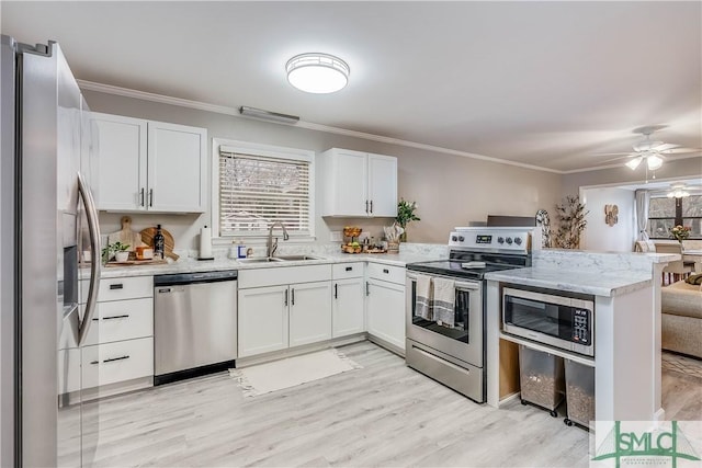 kitchen with sink, kitchen peninsula, ceiling fan, white cabinetry, and stainless steel appliances