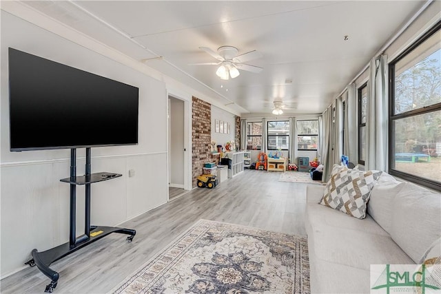 living room with ceiling fan, plenty of natural light, and light wood-type flooring