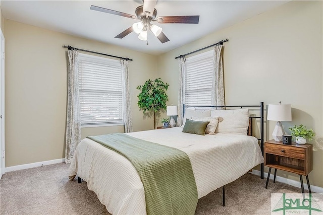 bedroom with multiple windows, ceiling fan, and light colored carpet