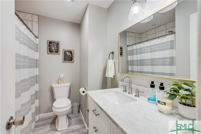 bathroom featuring vanity, wood-type flooring, and toilet