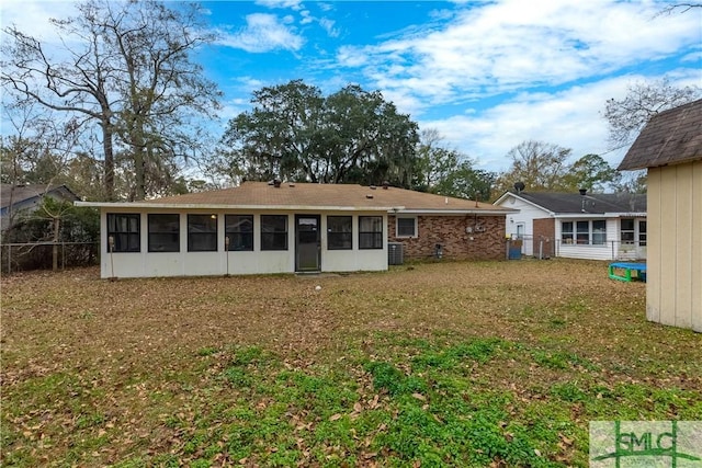 rear view of property with a lawn, a sunroom, and cooling unit