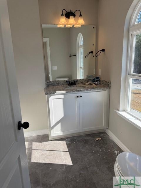 bathroom featuring tile patterned flooring, vanity, a healthy amount of sunlight, and toilet