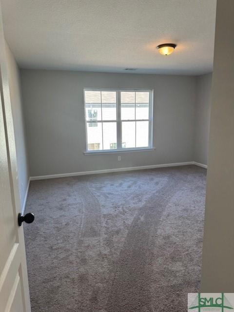 spare room with carpet and a textured ceiling