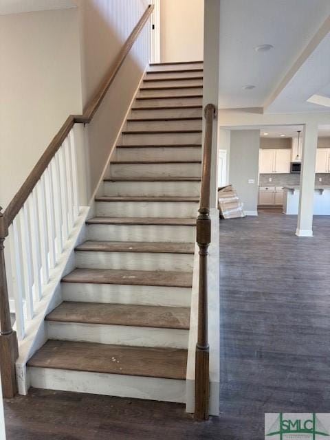 staircase featuring wood-type flooring