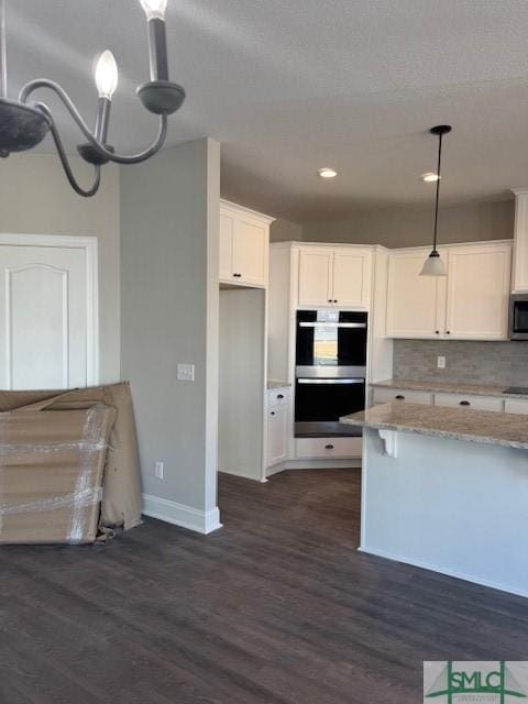 kitchen with tasteful backsplash, stainless steel appliances, pendant lighting, dark hardwood / wood-style floors, and white cabinetry