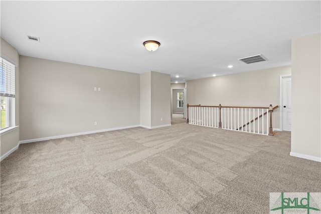 carpeted spare room with recessed lighting, baseboards, and visible vents