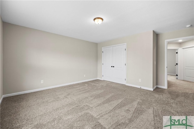 spare room featuring carpet and baseboards