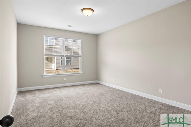 carpeted spare room with visible vents and baseboards