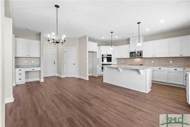 kitchen featuring dark wood-style floors, stainless steel appliances, decorative backsplash, white cabinetry, and a center island