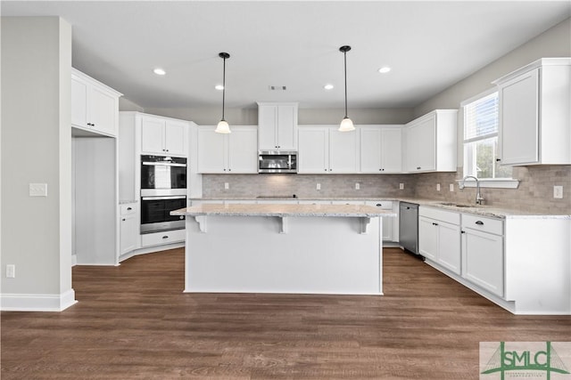 kitchen featuring appliances with stainless steel finishes, white cabinetry, and a sink