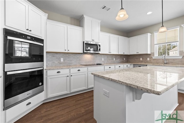 kitchen featuring stainless steel appliances, visible vents, and white cabinets