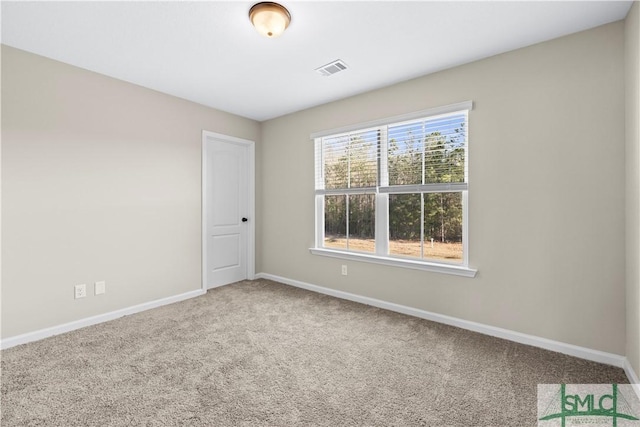 empty room with visible vents, carpet floors, and baseboards