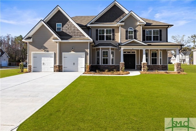 craftsman house featuring a front yard, driveway, covered porch, a garage, and stone siding