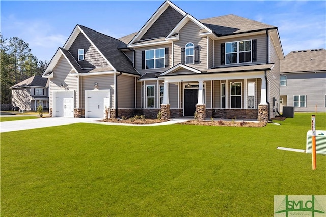 craftsman-style home featuring central air condition unit, concrete driveway, a front yard, covered porch, and a garage