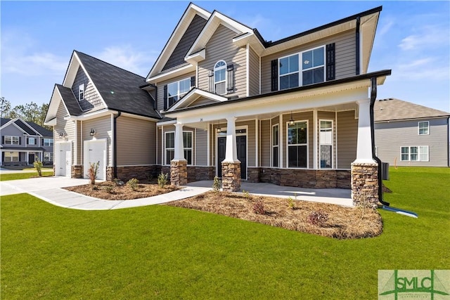 craftsman-style house featuring stone siding, a porch, concrete driveway, a front yard, and a garage