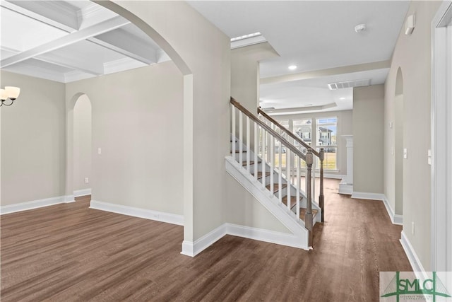 interior space with visible vents, baseboards, stairs, wood finished floors, and arched walkways