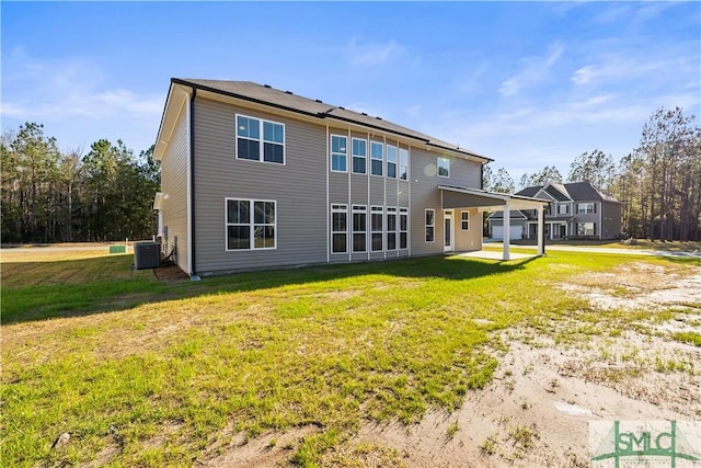 rear view of house featuring a lawn, a patio, and central AC