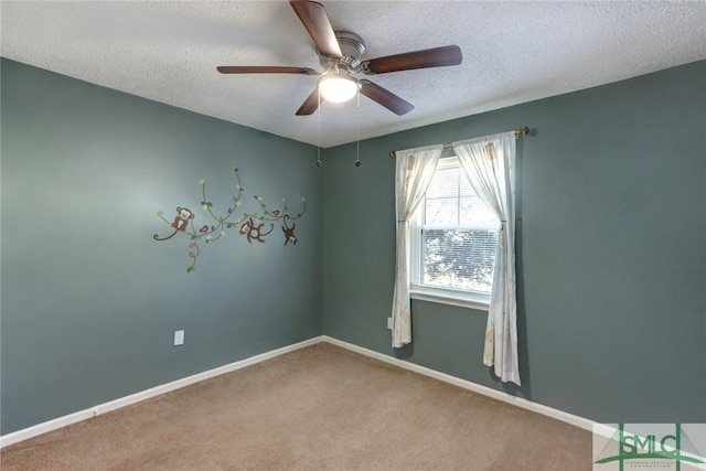 carpeted spare room featuring ceiling fan and a textured ceiling