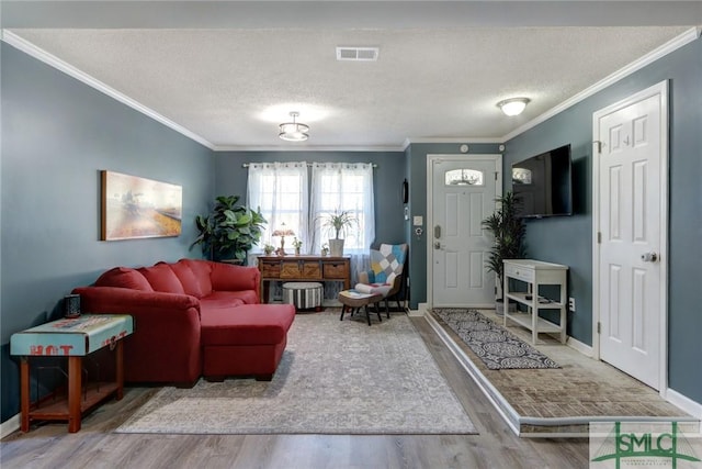 living room featuring a textured ceiling, hardwood / wood-style flooring, and ornamental molding