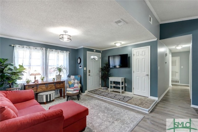 living room with crown molding, hardwood / wood-style floors, and a textured ceiling