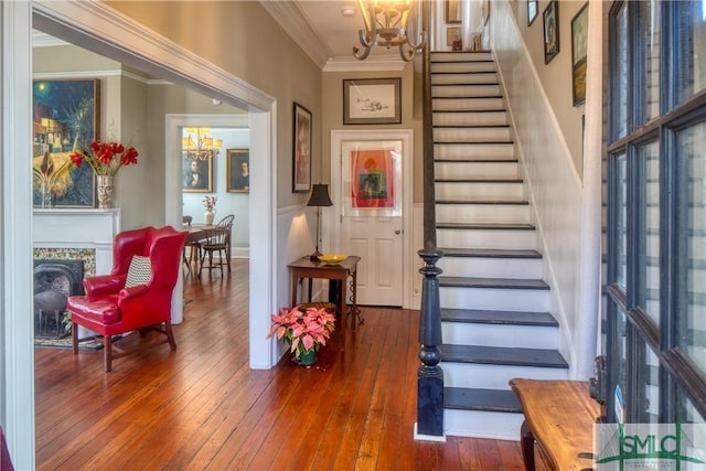 foyer entrance featuring hardwood / wood-style flooring, a notable chandelier, and ornamental molding