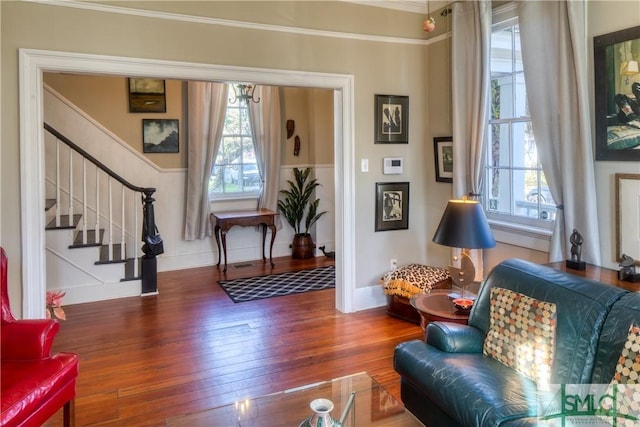 living area with a healthy amount of sunlight, ornamental molding, and dark wood-type flooring