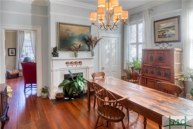 dining space featuring a wealth of natural light, crown molding, wood-type flooring, and a notable chandelier