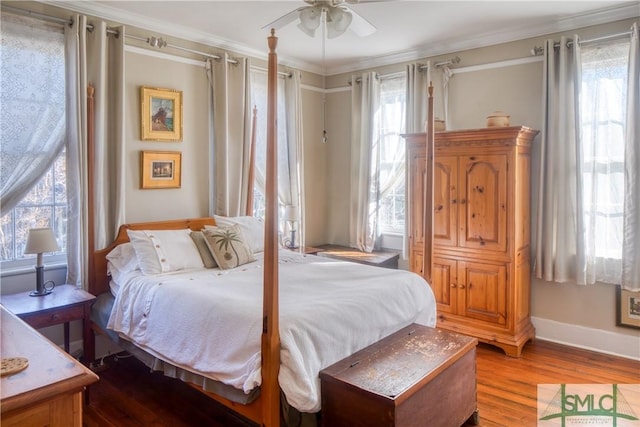 bedroom featuring multiple windows, ceiling fan, ornamental molding, and hardwood / wood-style flooring