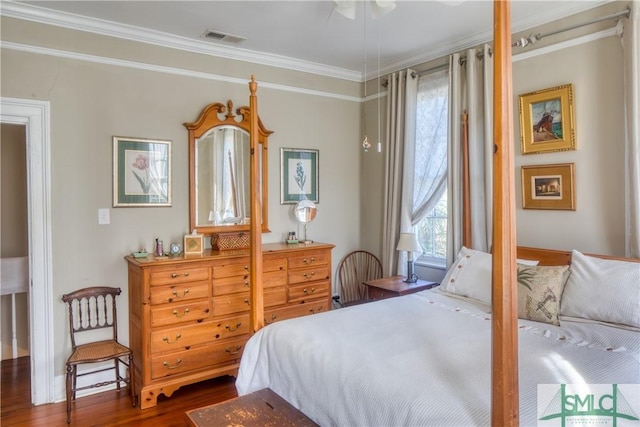 bedroom featuring crown molding and dark wood-type flooring