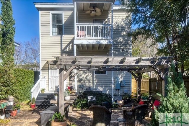 rear view of property featuring a pergola and a balcony