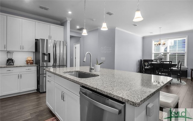 kitchen with light stone countertops, a kitchen island with sink, white cabinets, and stainless steel appliances