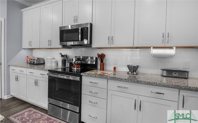 kitchen featuring light stone countertops, dark hardwood / wood-style flooring, stainless steel appliances, and white cabinetry