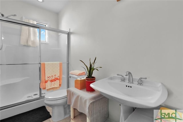 bathroom with an enclosed shower, toilet, and sink