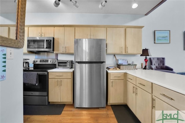 kitchen featuring kitchen peninsula, light brown cabinets, stainless steel appliances, and light hardwood / wood-style floors