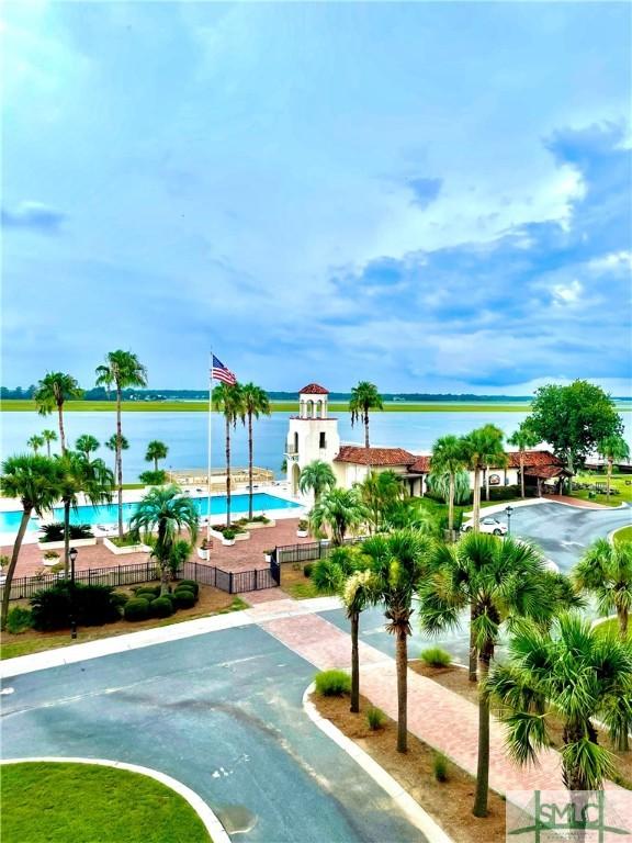 view of swimming pool featuring a patio and a water view