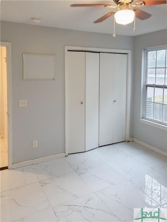 unfurnished bedroom featuring ceiling fan and a closet