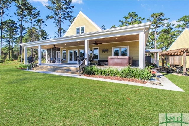 back of house featuring ceiling fan, a yard, a hot tub, and a porch