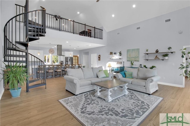 living room featuring light hardwood / wood-style flooring and high vaulted ceiling