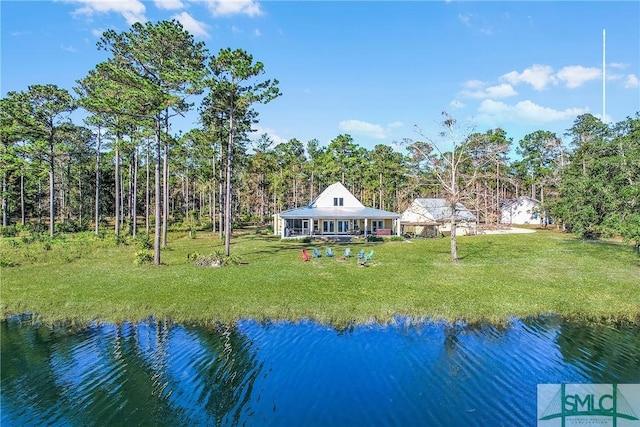 back of house featuring a lawn and a water view