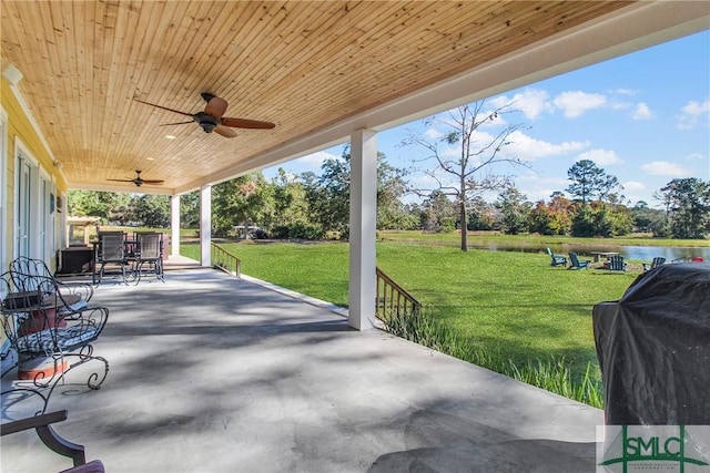 view of patio / terrace featuring grilling area, a water view, and ceiling fan