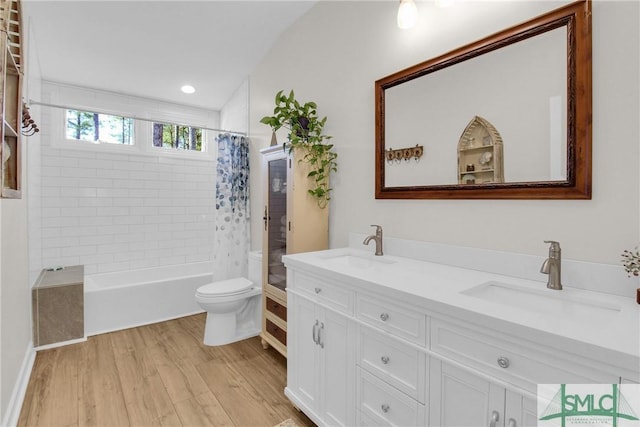 full bathroom with hardwood / wood-style flooring, vanity, toilet, and shower / bath combo