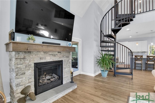 living room featuring a stone fireplace and light hardwood / wood-style floors