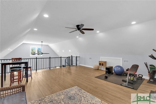 exercise room with hardwood / wood-style flooring, ceiling fan, and lofted ceiling