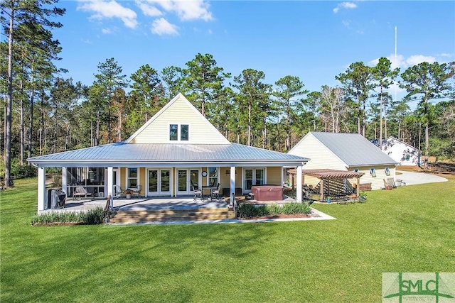 rear view of property with a yard, a pergola, a hot tub, and a patio area