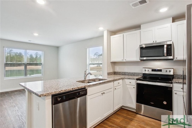 kitchen featuring sink, stainless steel appliances, white cabinetry, and kitchen peninsula