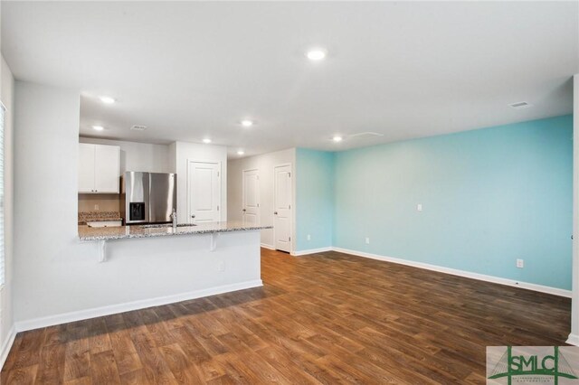 unfurnished living room with dark wood-type flooring and sink