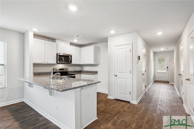 435 Salvia Rd, Bloomingdale, GA 31302 - kitchen featuring a peninsula, light stone countertops, stainless steel appliances, dark wood finished floors, and white cabinetry
